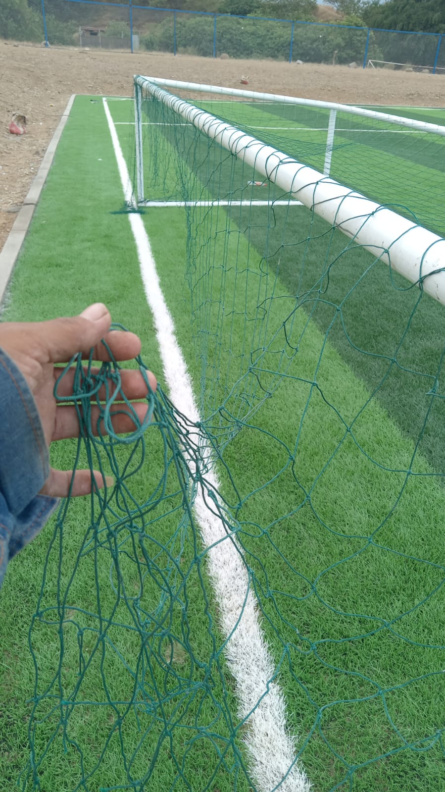 Instalación de malla y portería en cancha de grass sintético
